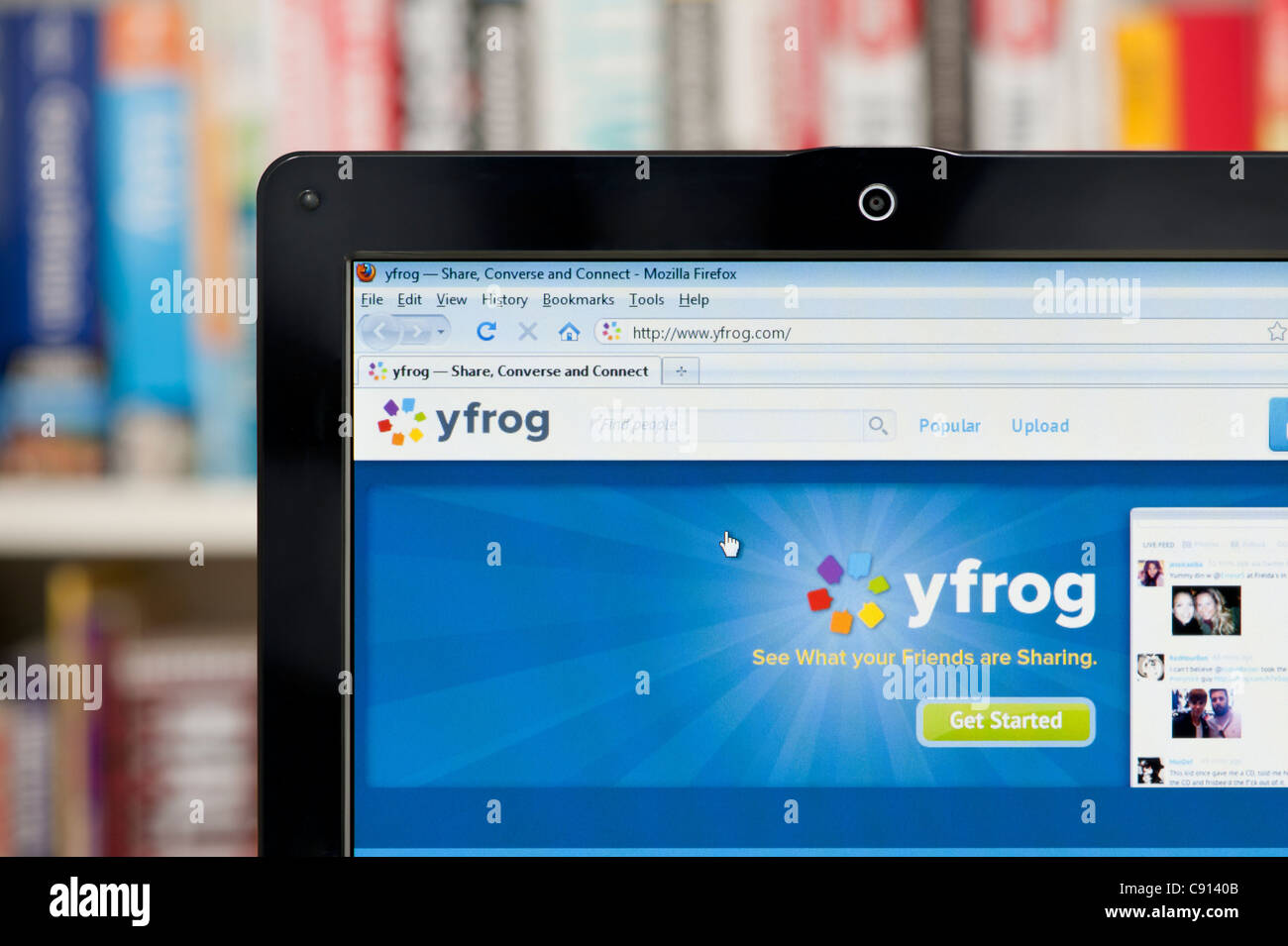 The Yfrog website shot against a bookcase background (Editorial use only: print, TV, e-book and editorial website). Stock Photo