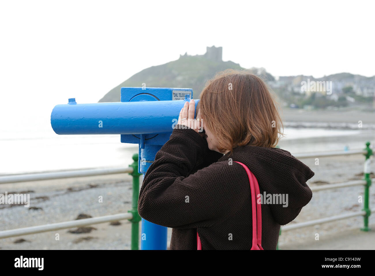 female looking through telescope criccieth sea front gwynedd north