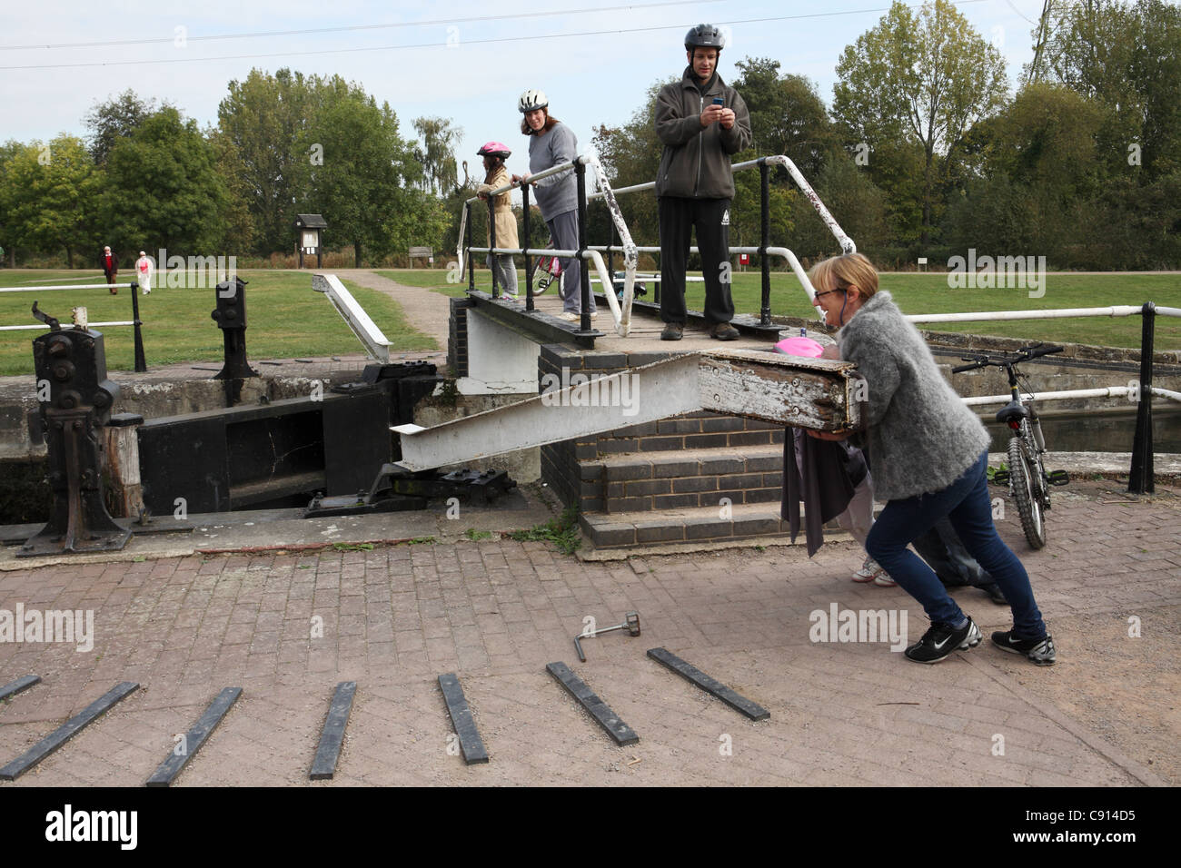 Woman closing a canal lock gate, Lee Valley country park, Hertfordshire
