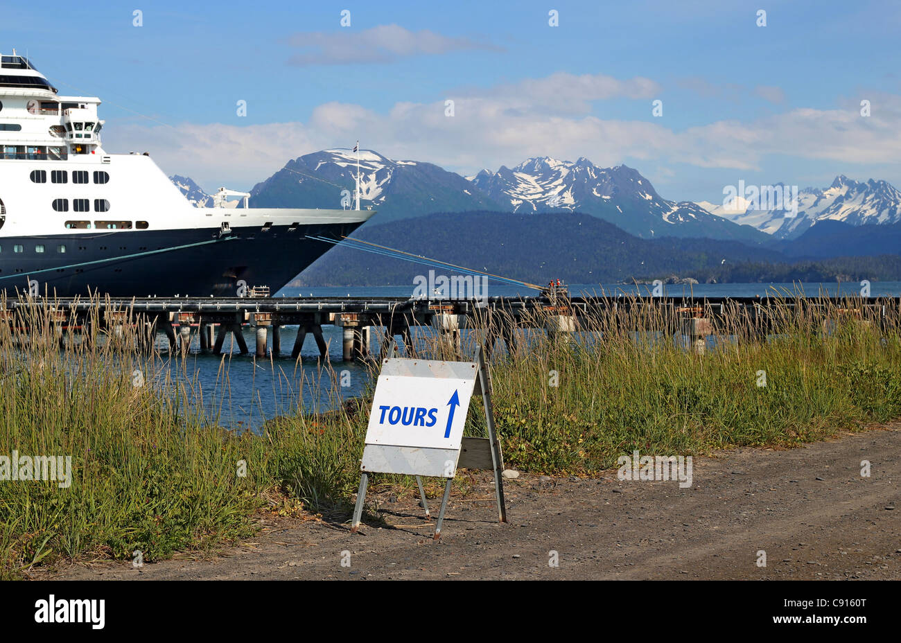 Tour sign for cruise ship passengers with the cruise ship in the background in Homer, Alaska on a sunny day. Stock Photo