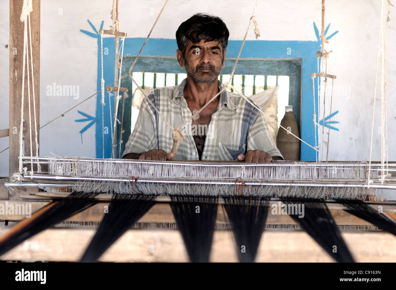 A tailor from Kutch using traditional methods to weave cotton. Stock Photo