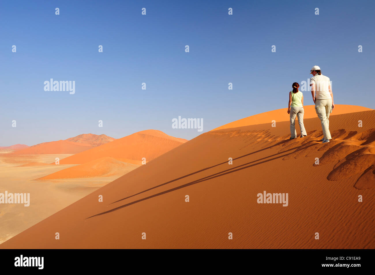 Two women walking on red sand dune in Sossusvlei dune 45 Sossusvlei ...