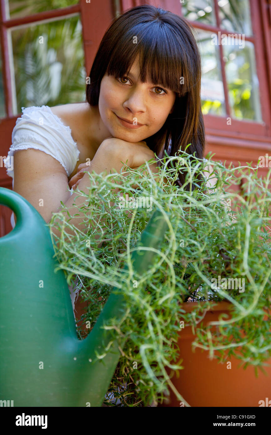 Woman sitting with plants on back porch Stock Photo - Alamy