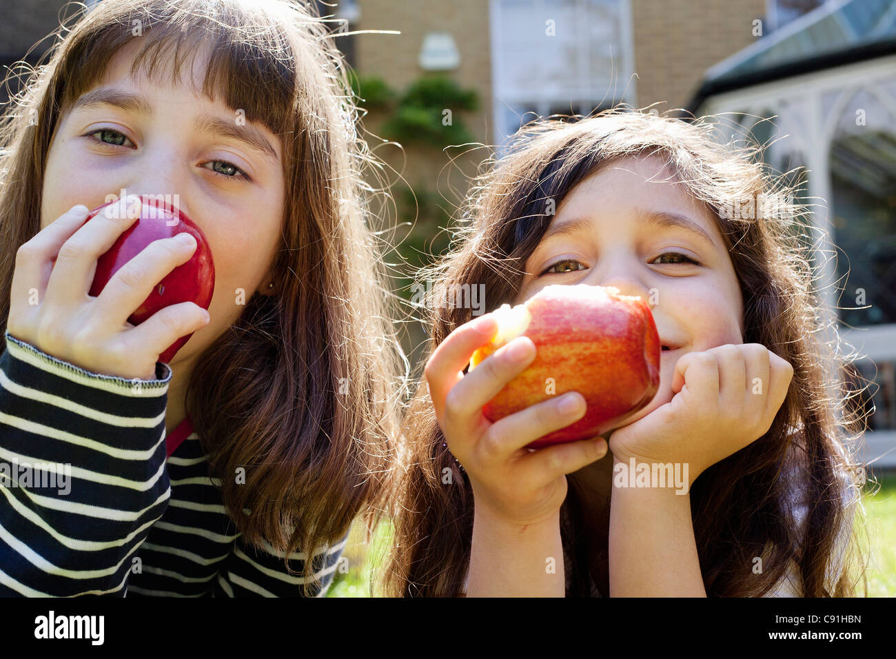 Girls eating apples outdoors Stock Photo Alamy