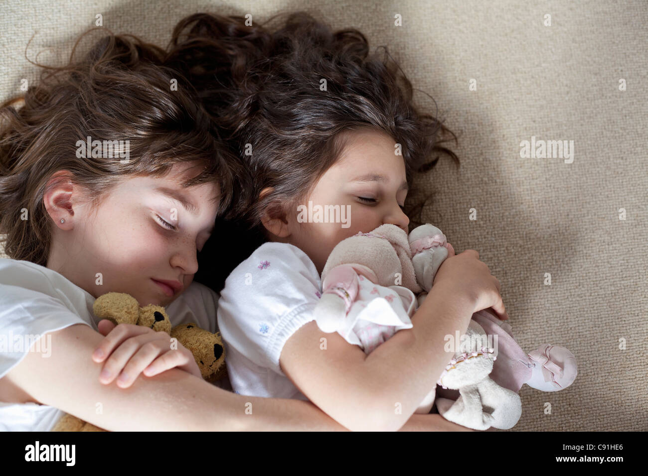 Girls napping on carpet together Stock Photo Alamy