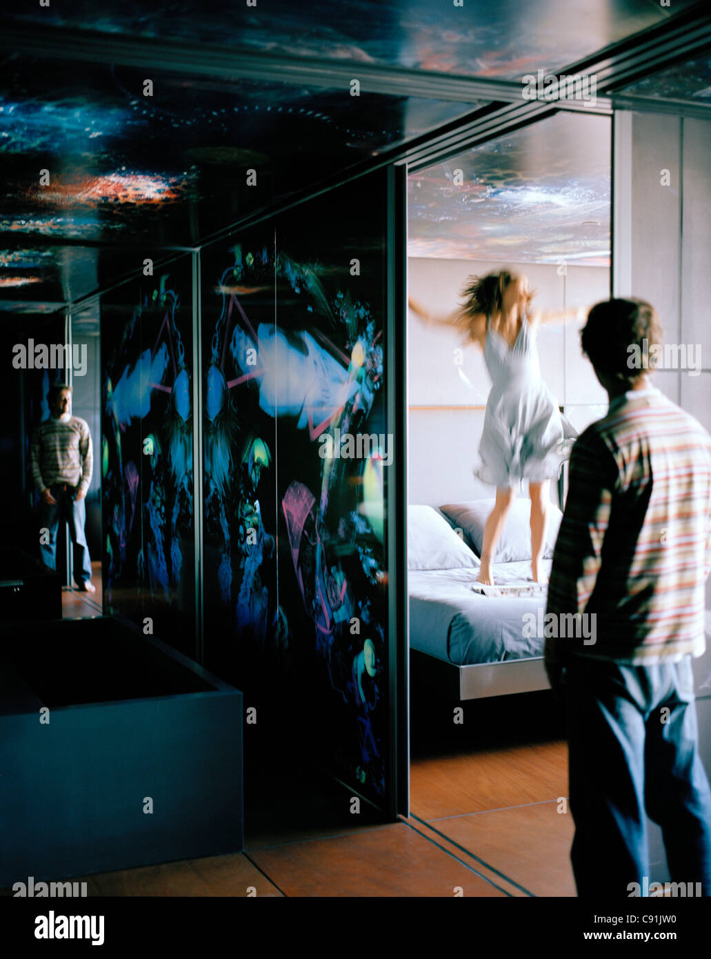 Reflection of woman jumping on the bed Suite on the 13th Floor Designed by Jean Nouvel Hotel Silken Puerta America Madrid Spain Stock Photo