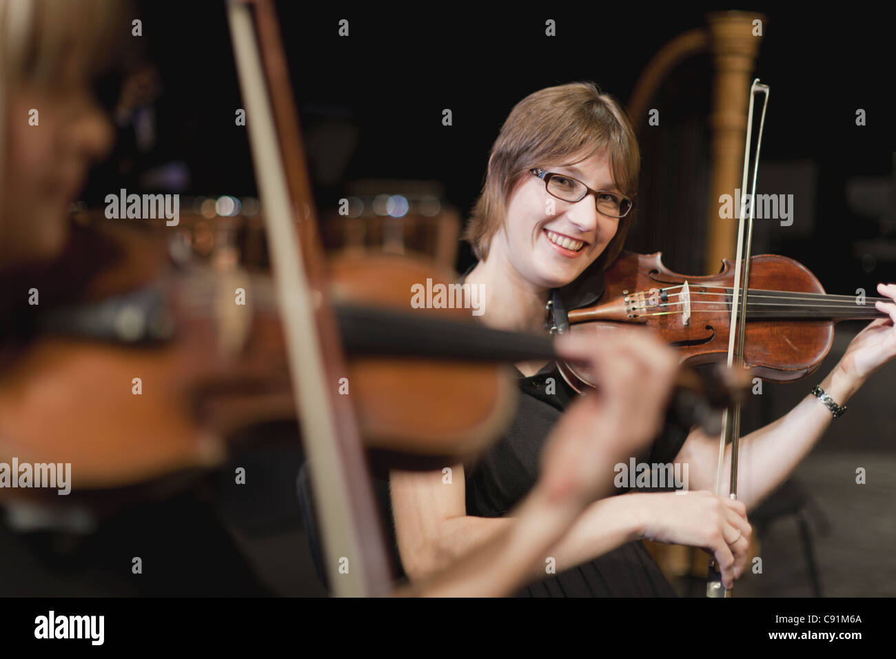 Violin players in orchestra Stock Photo