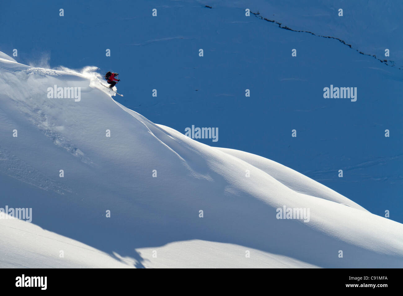 Man backcountry skiing powder snow on the south face of Eddies Ridge ...