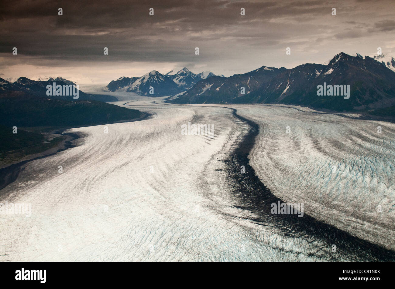 Aerial view of Knik Glacier under the dark clouds of a summer rain storm, Knik Valley, Southcentral Alaska, Summer Stock Photo
