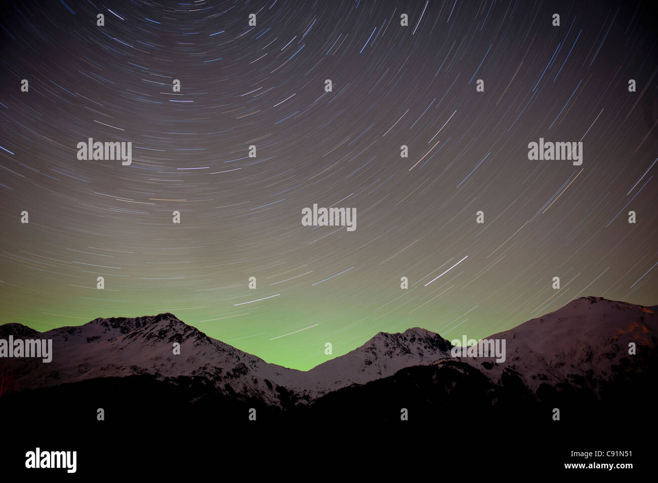 time elapse view of the night sky and star trails over the Chugach Mountains, Portage Valley, Southcentral Alaska, Winter Stock Photo