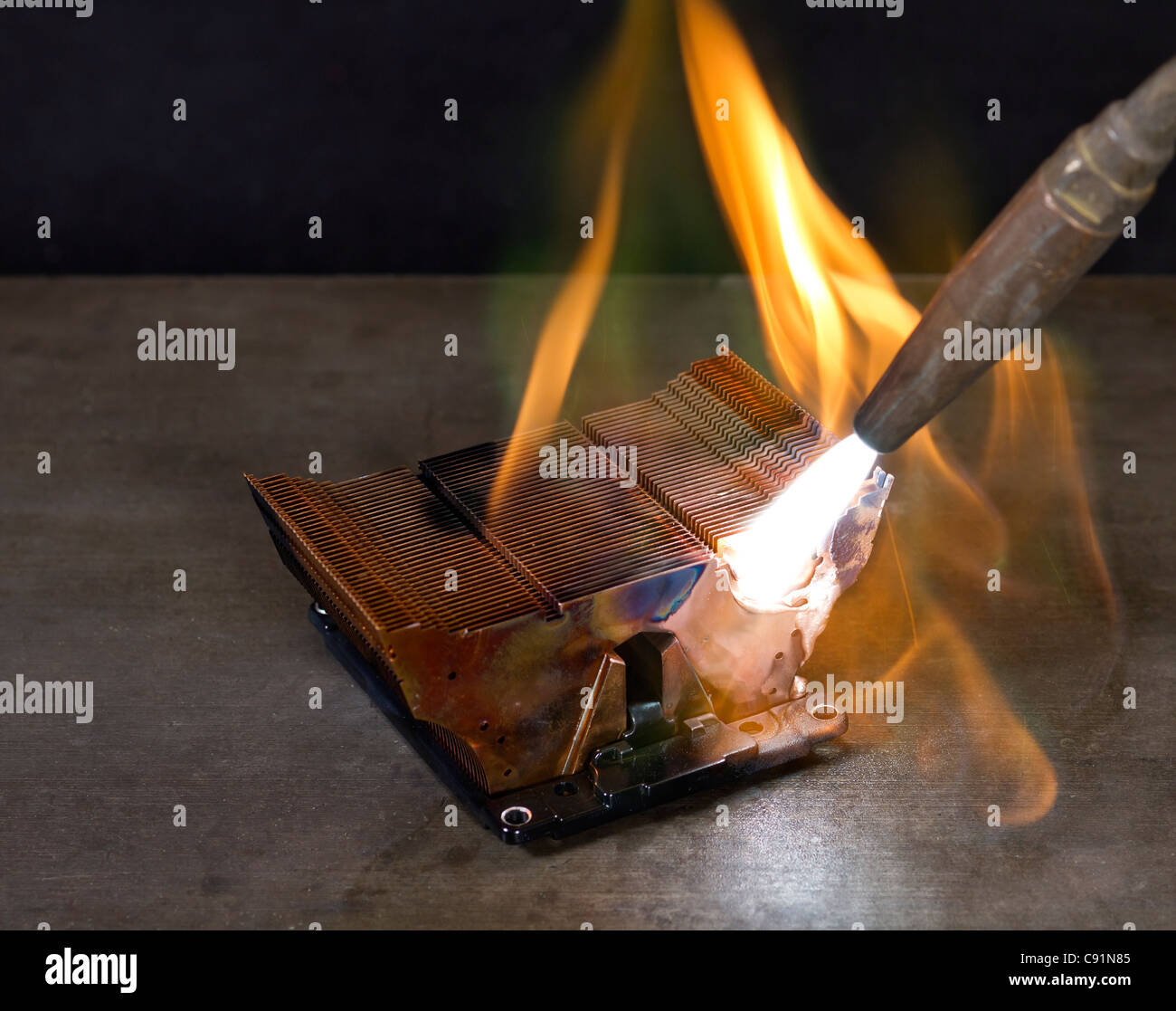 melting heat sink and welding torch on metallic ground Stock Photo