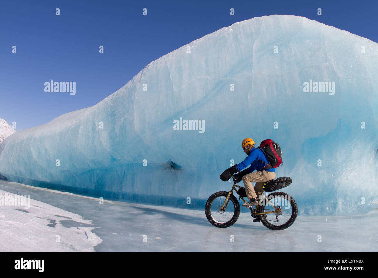 Man Fat Tire mountain biking on ice at the Knik Glacier, Chugach Mountains, Southcentral Alaska, Winter Stock Photo