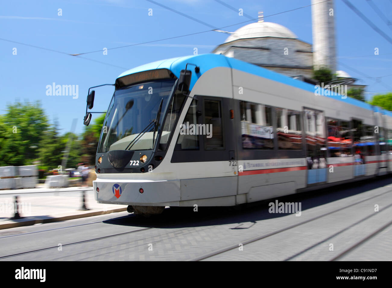 Bombardier Flexity Swift tram speeding past a mosque in central Istanbul, Turkey Stock Photo