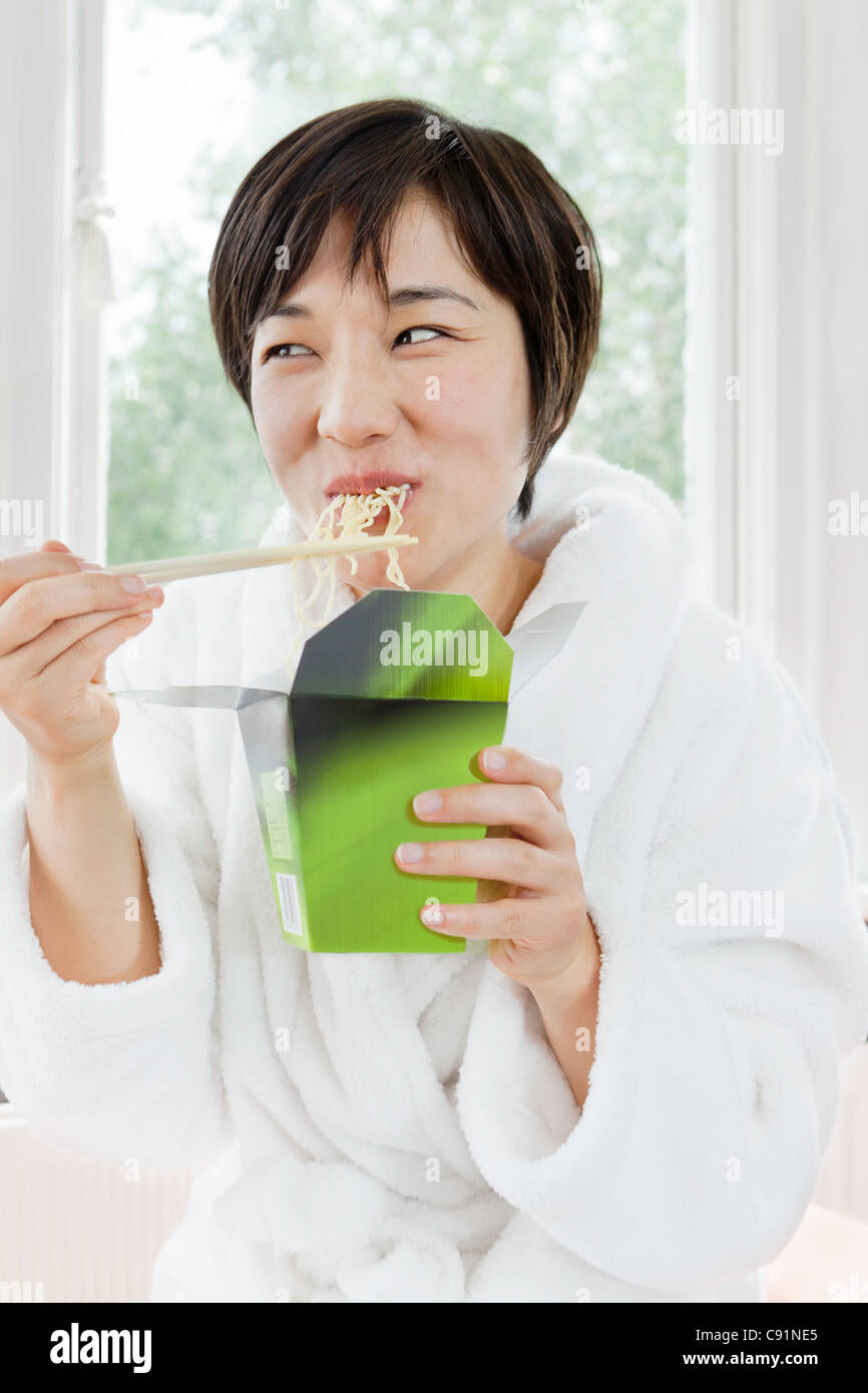 Woman in bathrobe eating Chinese food Stock Photo Alamy