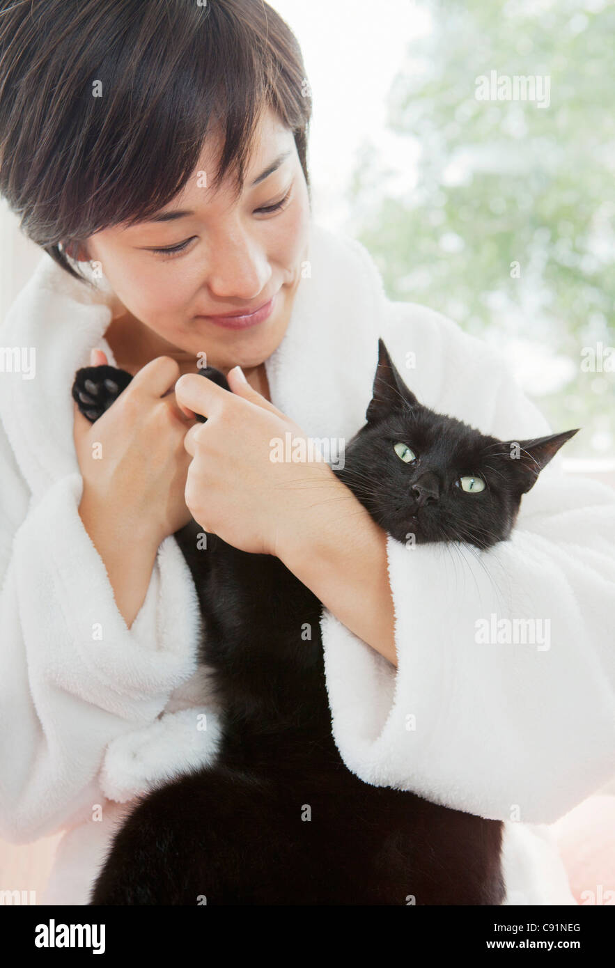 Woman in bathrobe holding cat Stock Photo Alamy