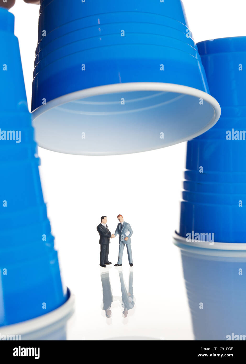 business figurines placed under plastic coffee cups Stock Photo
