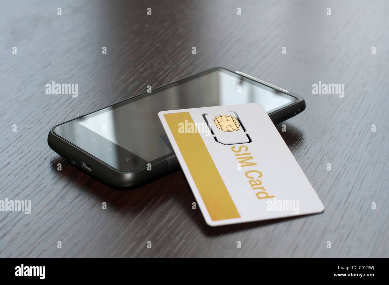 SIM card and mobile phone on table Stock Photo