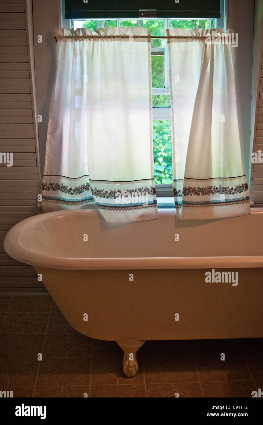 Old fashioned claw foot cast iron bathtub in summer vacation house