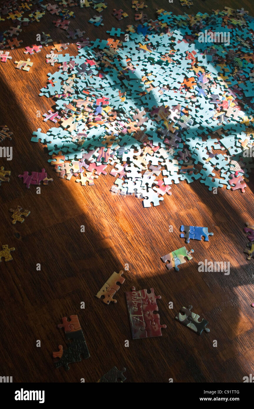 Colorful puzzle pieces on family room floor Stock Photo