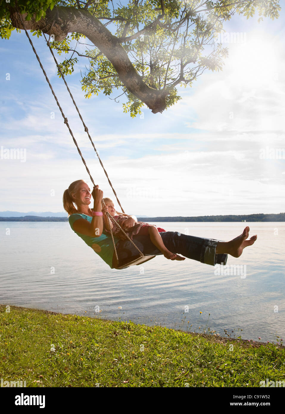 Mother and daughter swinging from tree Stock Photo Alamy