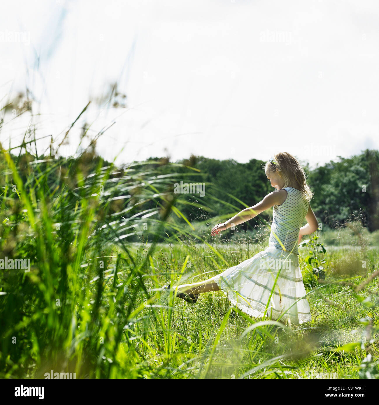 Girl playing in tall grass in field Stock Photo - Alamy