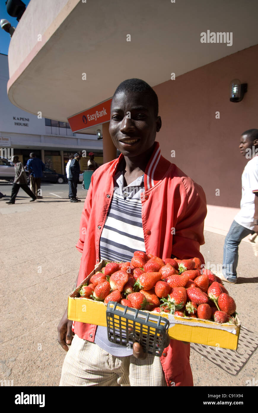 Vendors sell fresh strawberries on Chilembwe rd in the centre of Blantyre town. Stock Photo