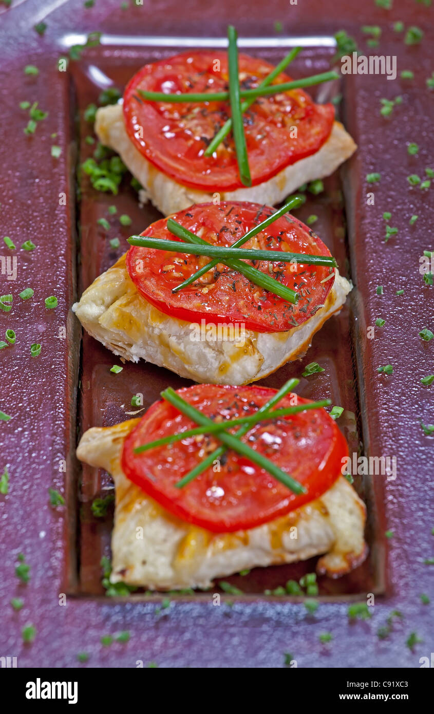 Puff pastry pockets filled with cheese, grilled tomato  Stock Photo