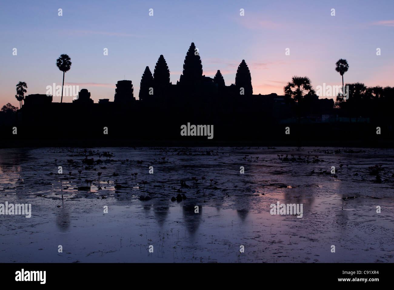 Sunrise at Angkor Wat viewed from inside the outer walls eastwards over the central temple complex a temple complex built for Stock Photo