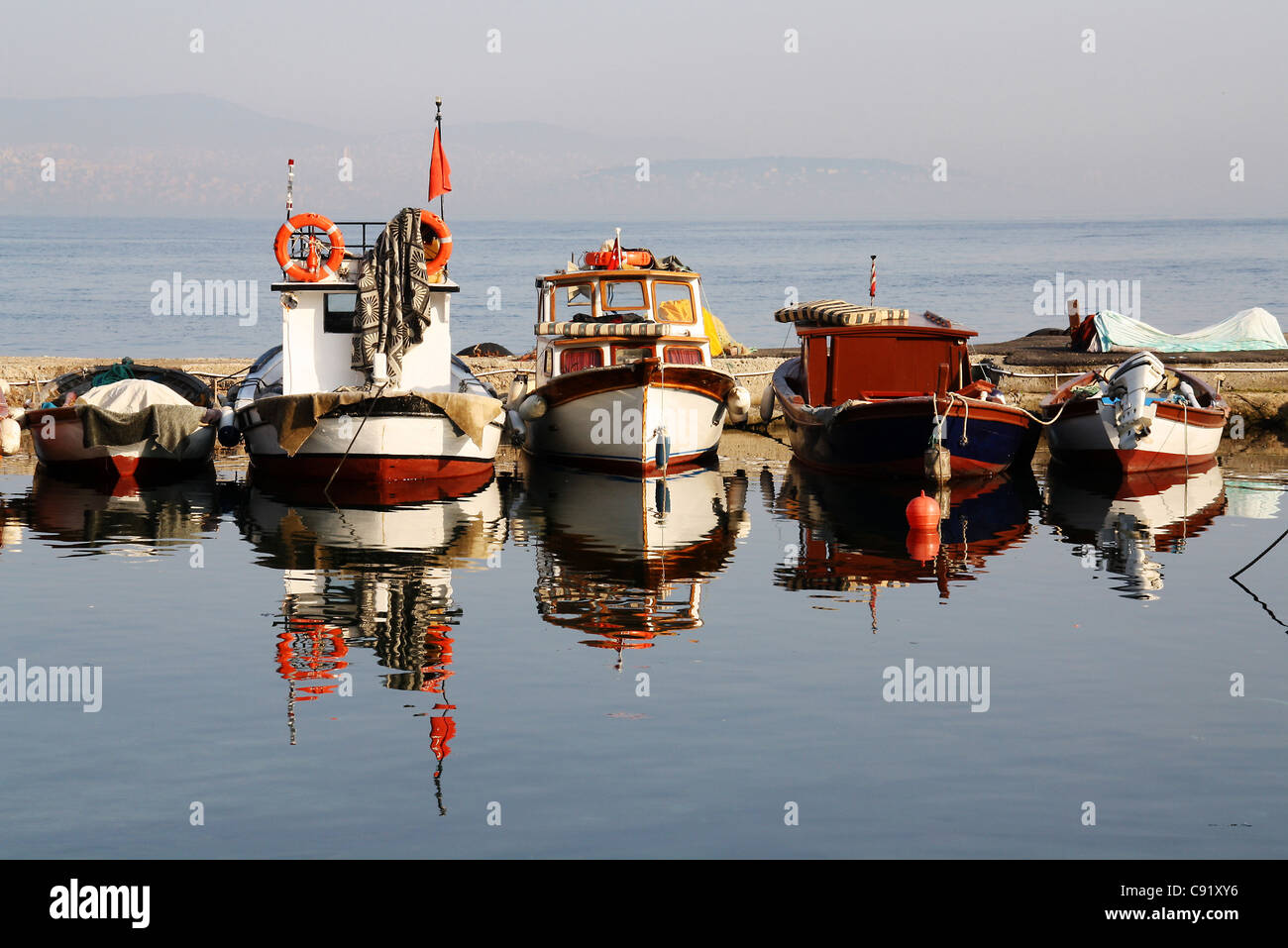 Fishing boats in harbor, reflected in the water Stock Photo - Alamy