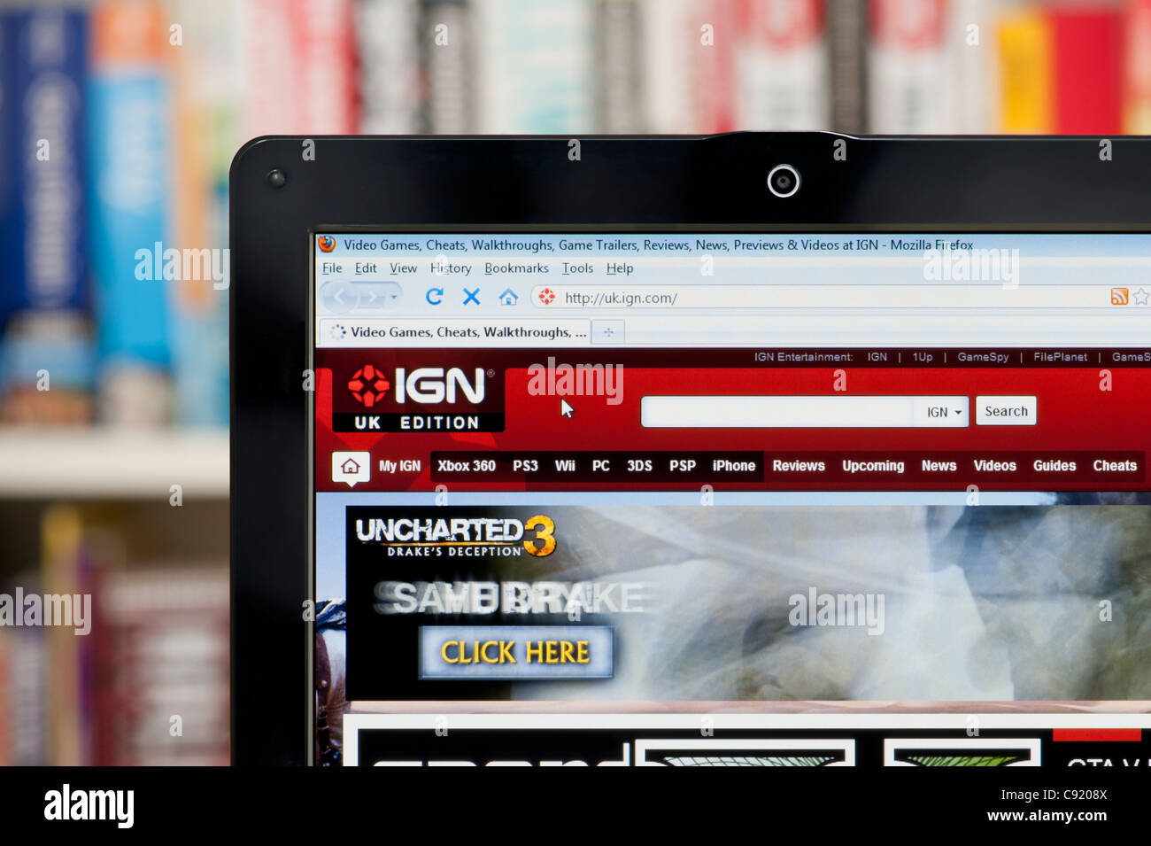 The IGN website shot against a bookcase background (Editorial use only:  print, TV, e-book and editorial website Stock Photo - Alamy