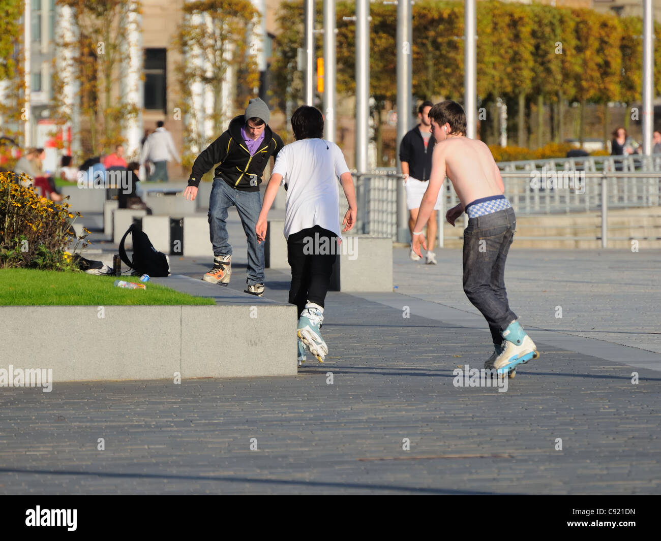Youths roller blading on the River Clyde walkway at the Broomilaw Stock Photo