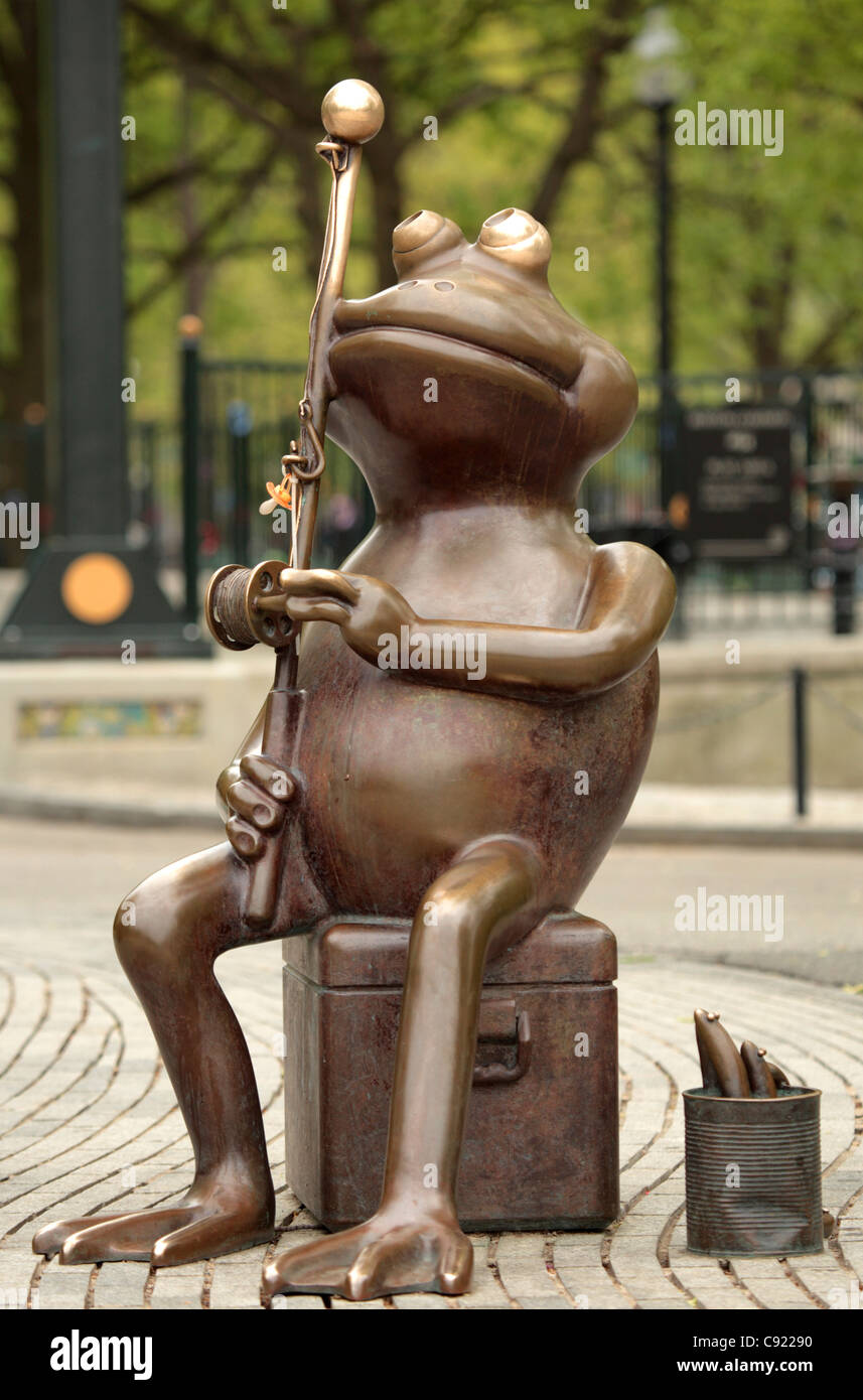 A bronze statue of a frog fishing stands on the shores of the Frog Pond