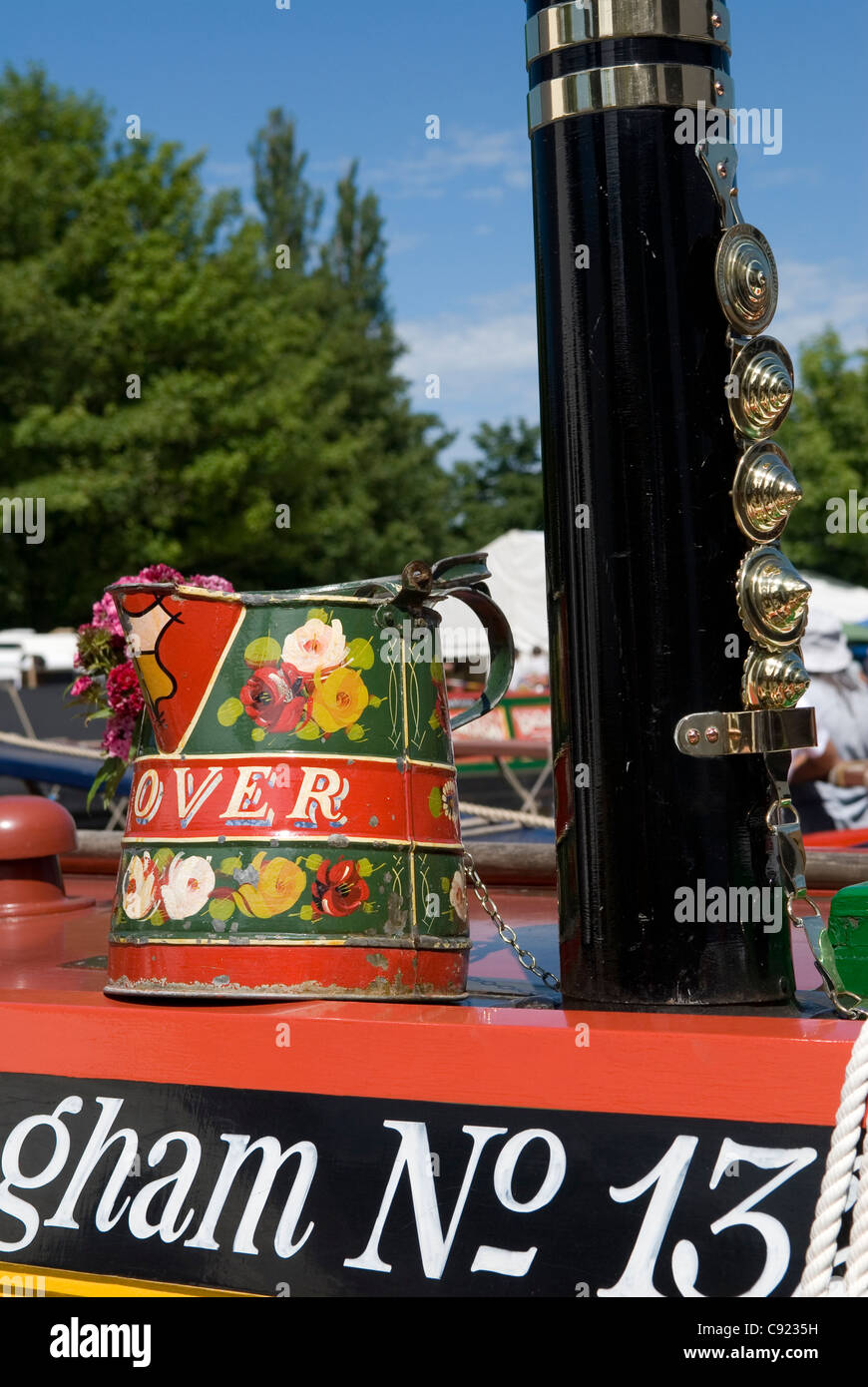 Grand Union Canal. A colourful painted pot and chimney adorned with polished brasses on a narrowboat at the Braunston Historic Stock Photo