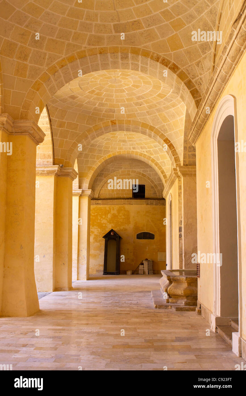 Vaulted stone ceilings in a passageway to the side of Neptune's Courtyard in the grounds of the Grandmaster's Palace built in Stock Photo