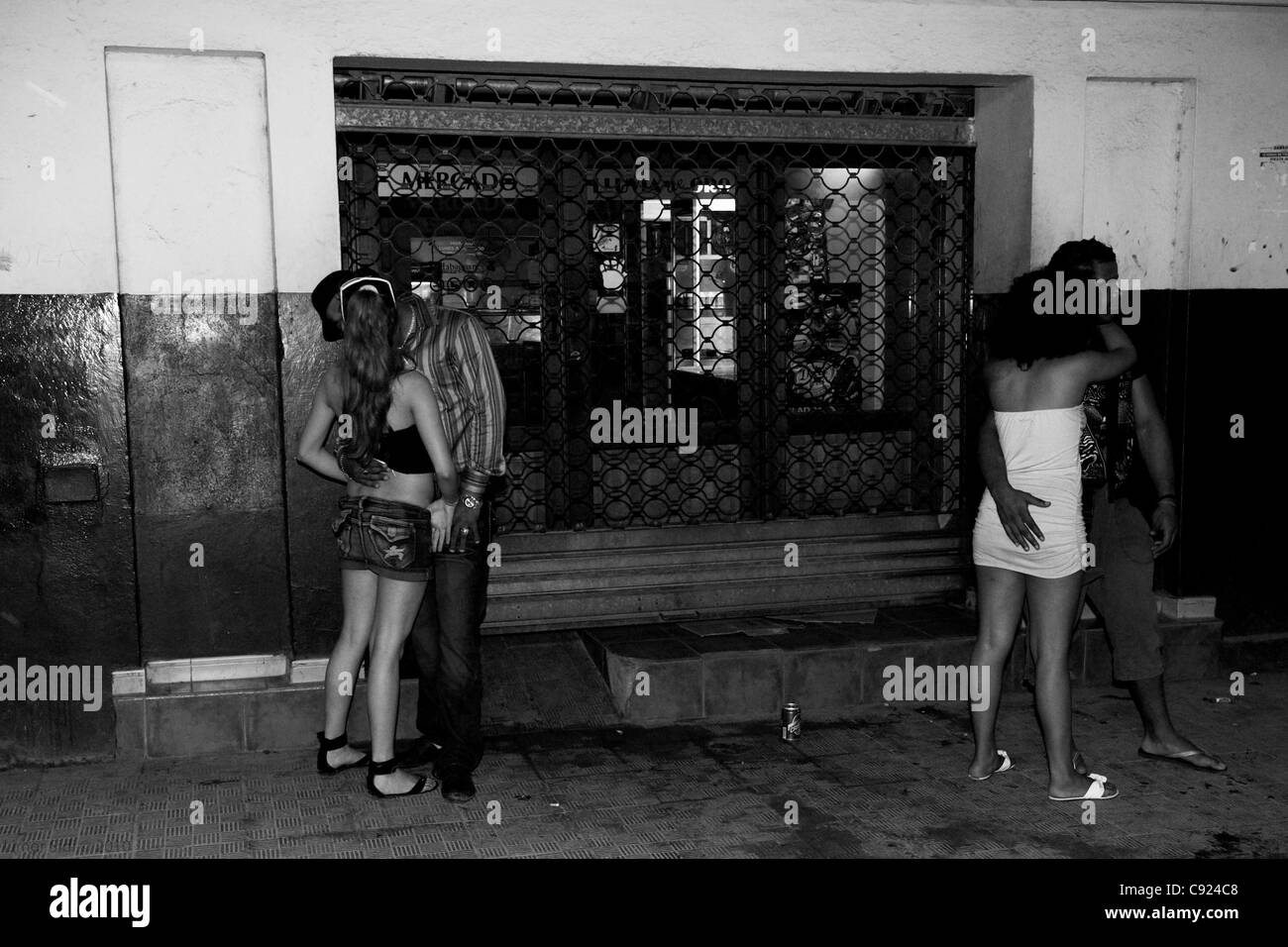 Two couples making out in the streets of Havana, Cuba. Black & white image. Stock Photo