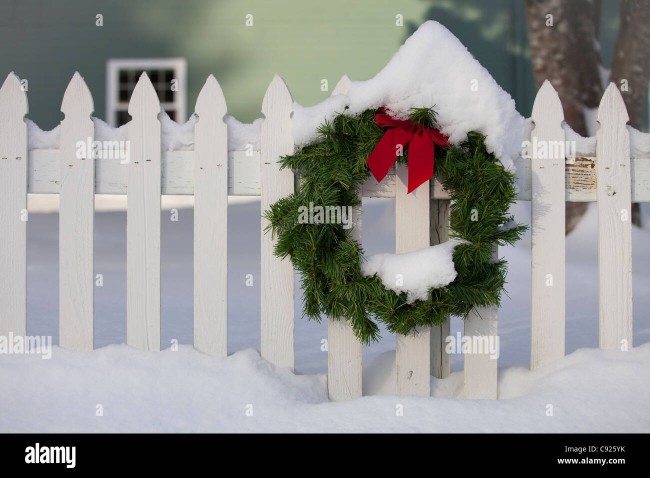 Christmas wreath on white picket fence covered with snow at the Kodiak