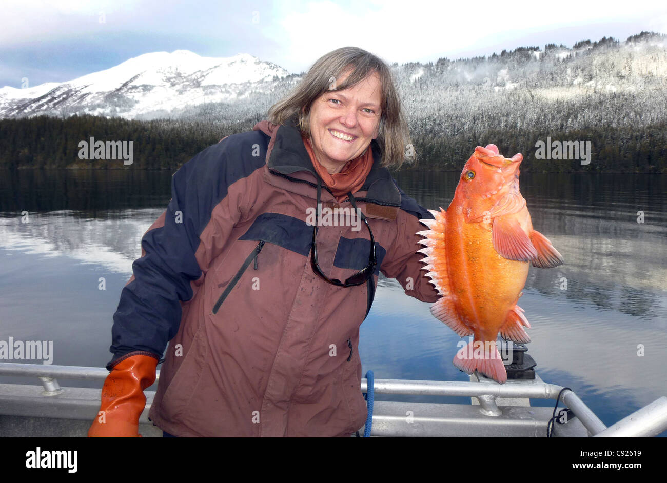 Woman holding a yelloweye rockfish (red snapper) in a bay near Homer, Kenai Peninsula, Southcentral Alaska Stock Photo