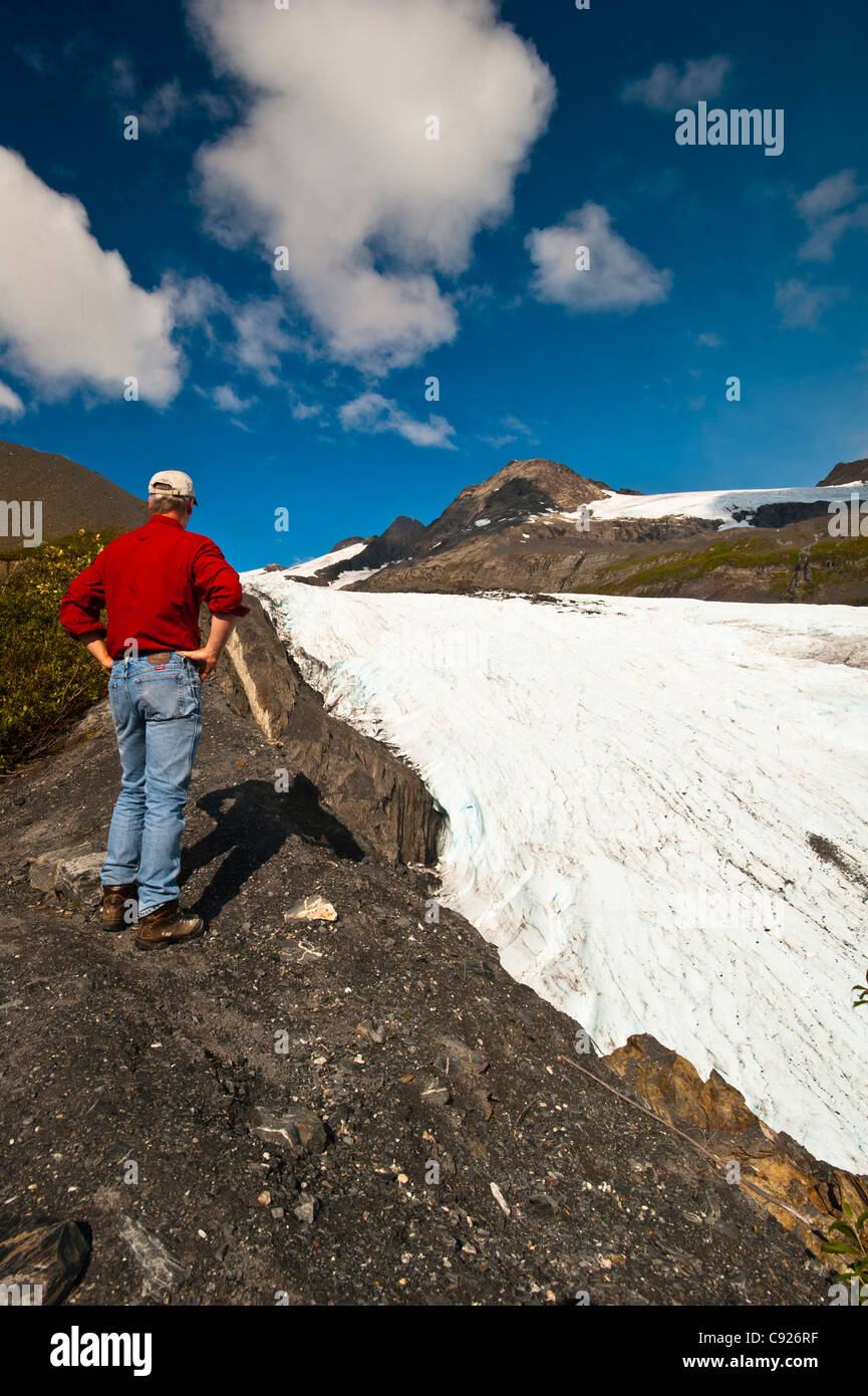 Male hiker enjoys the view of Worthington Glacier along the Ridge Trail at Worthington Glacier State Recreation Area, Alaska Stock Photo