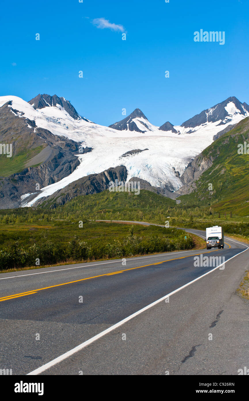 Scenic view of Worthington Glacier with a truck pulling a RV camp trailer on Richardson Highway in the foreground, Alaska Stock Photo