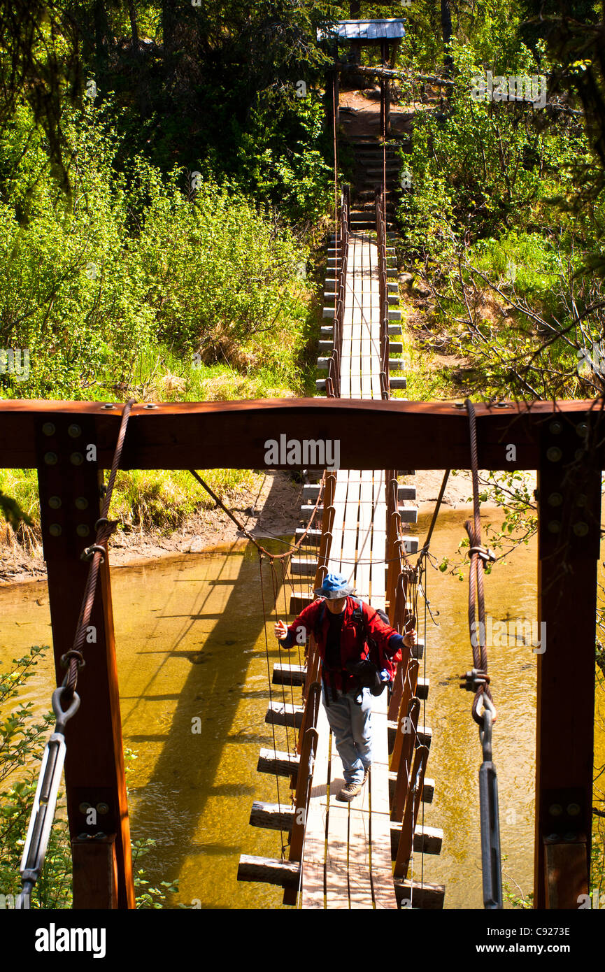 A father and son hiking across a suspension bridge that crosses Byers Creek on the Byers Lake