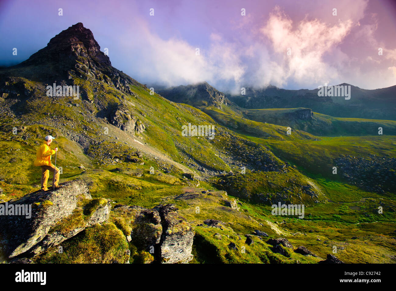 Man hiking near Hatcher Pass in the Talkeetna Mountains with Bald Ridge in the background, Southcentral Alaska, Summer Stock Photo