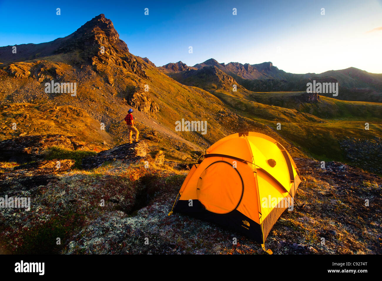 A man standing on a rock next to his tent while camping near Hatcher
