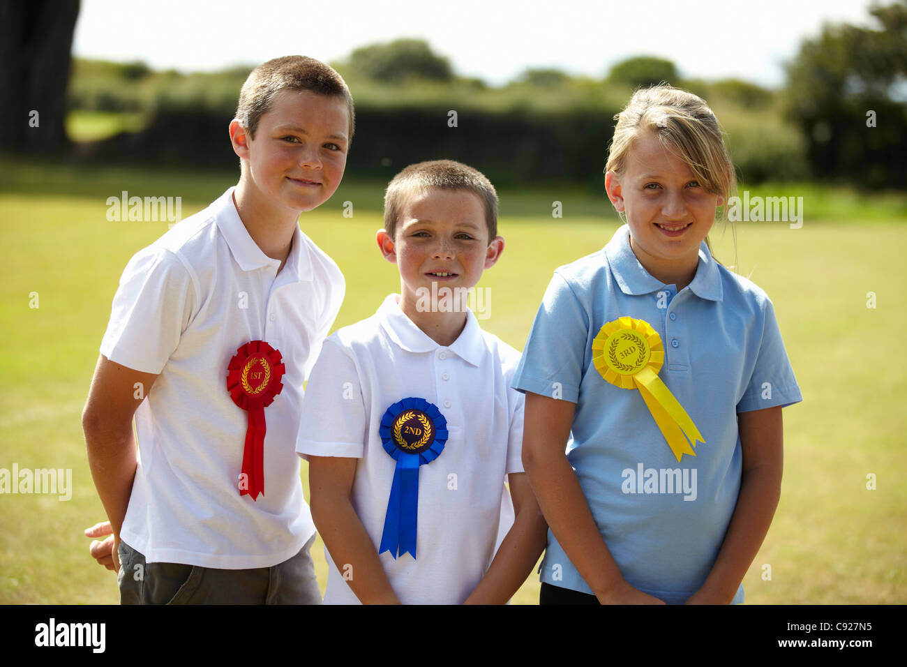 Children wearing ribbons in field Stock Photo - Alamy