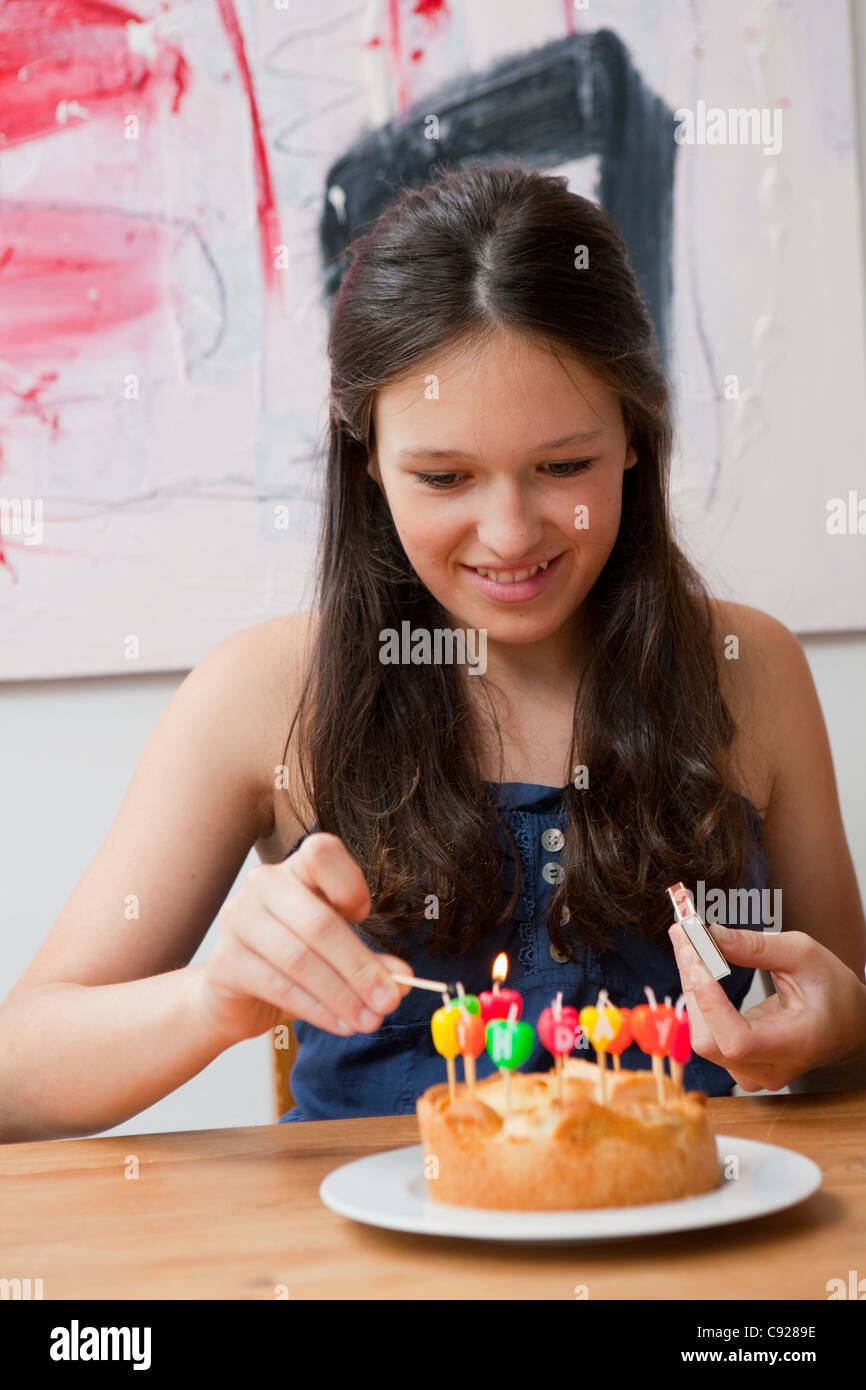 Girl lighting candles in birthday cake Stock Photo Alamy