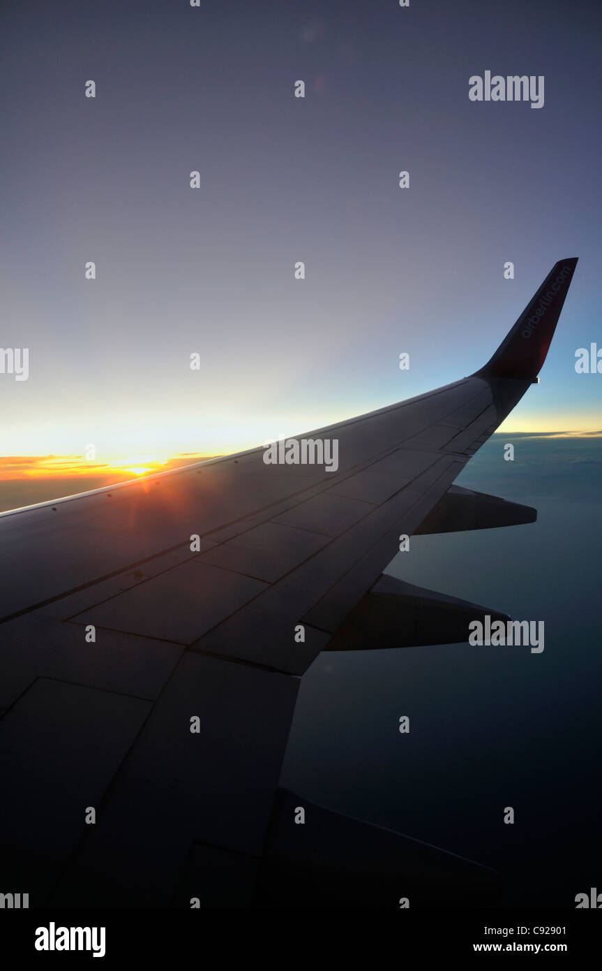 Silhouette of airplane wing with a sunset sky Stock Photo