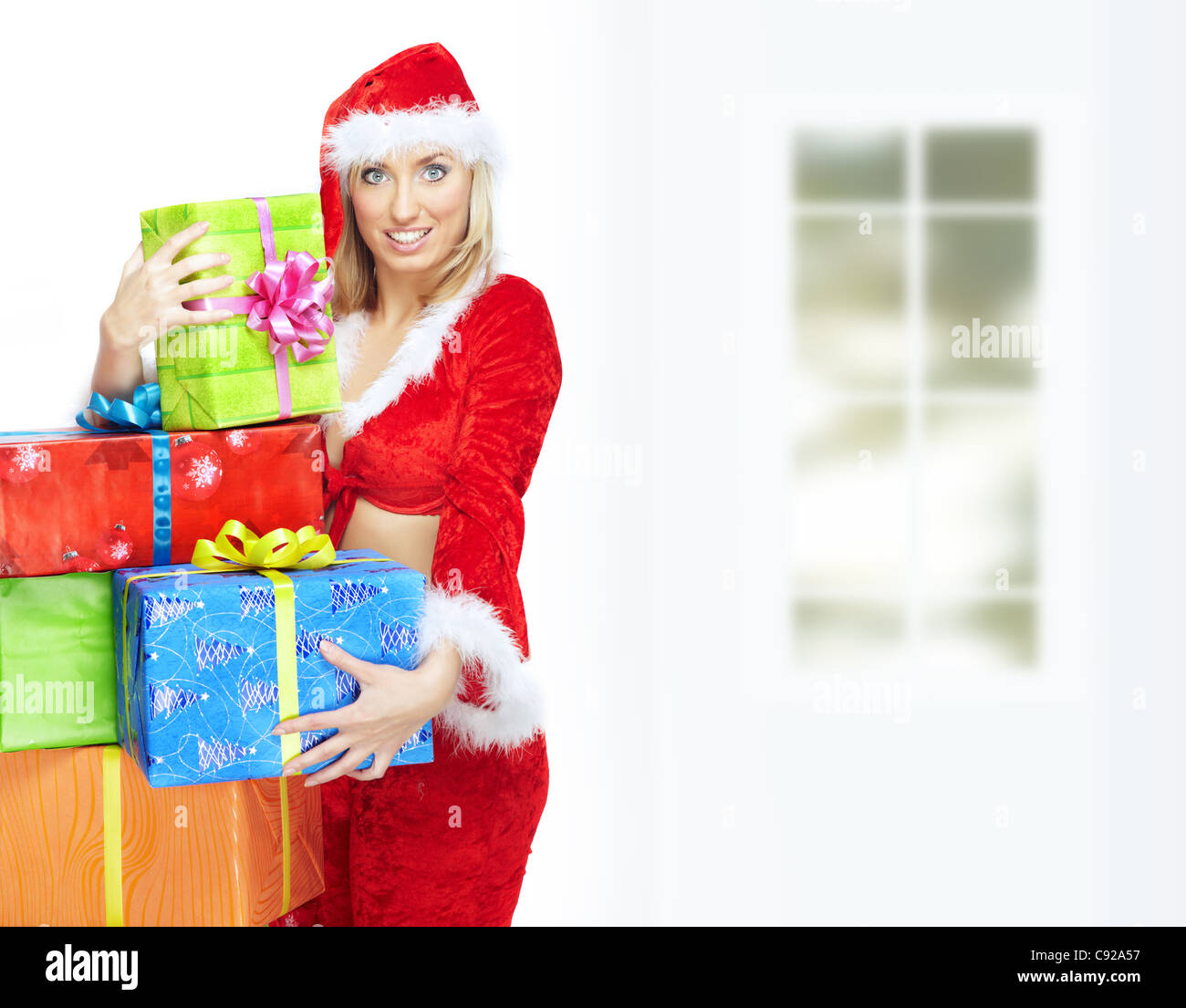 Smiling lady in Santa Claus costume with Christmas gift boxes Stock