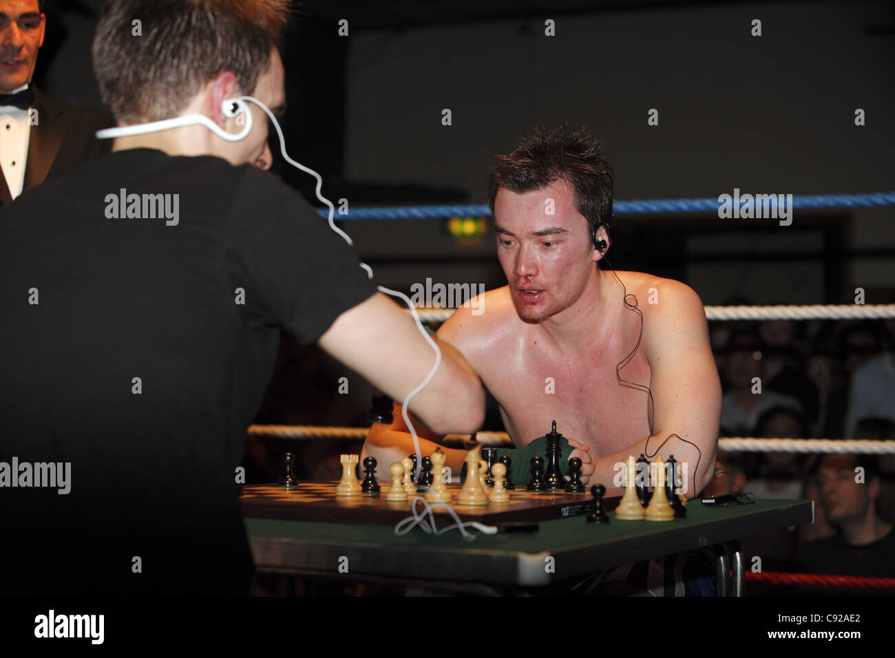 Chess boxers Arik Braun (R) and Felix Bartels sit in front of a chequer  board during the Chess Boxing Championships in Berlin, Germany, 28 July  2012. The chess boxing event took place