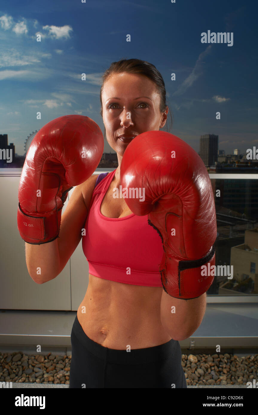 Boxer wearing gloves on urban rooftop Stock Photo