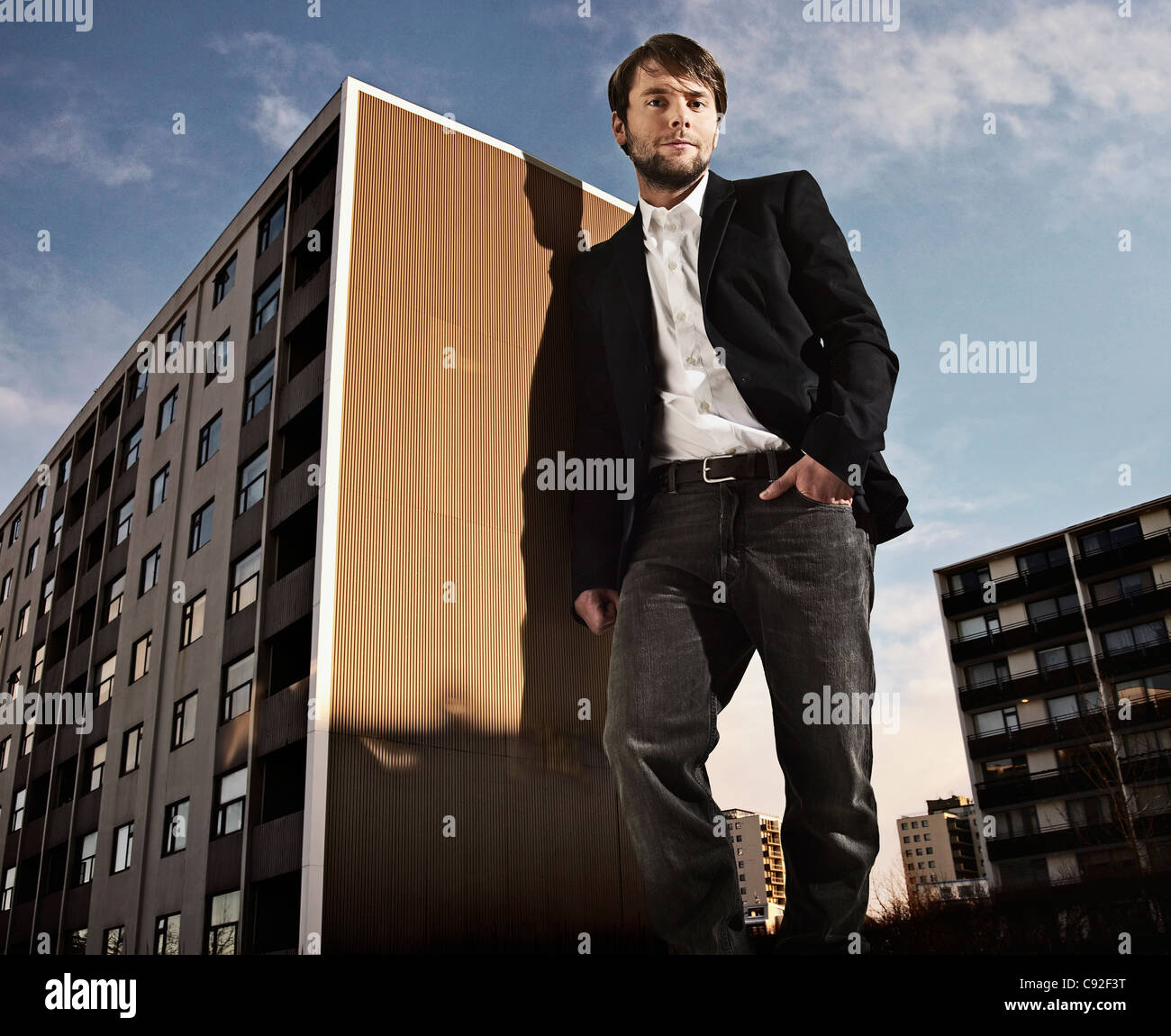 Oversized man leaning on building Stock Photo