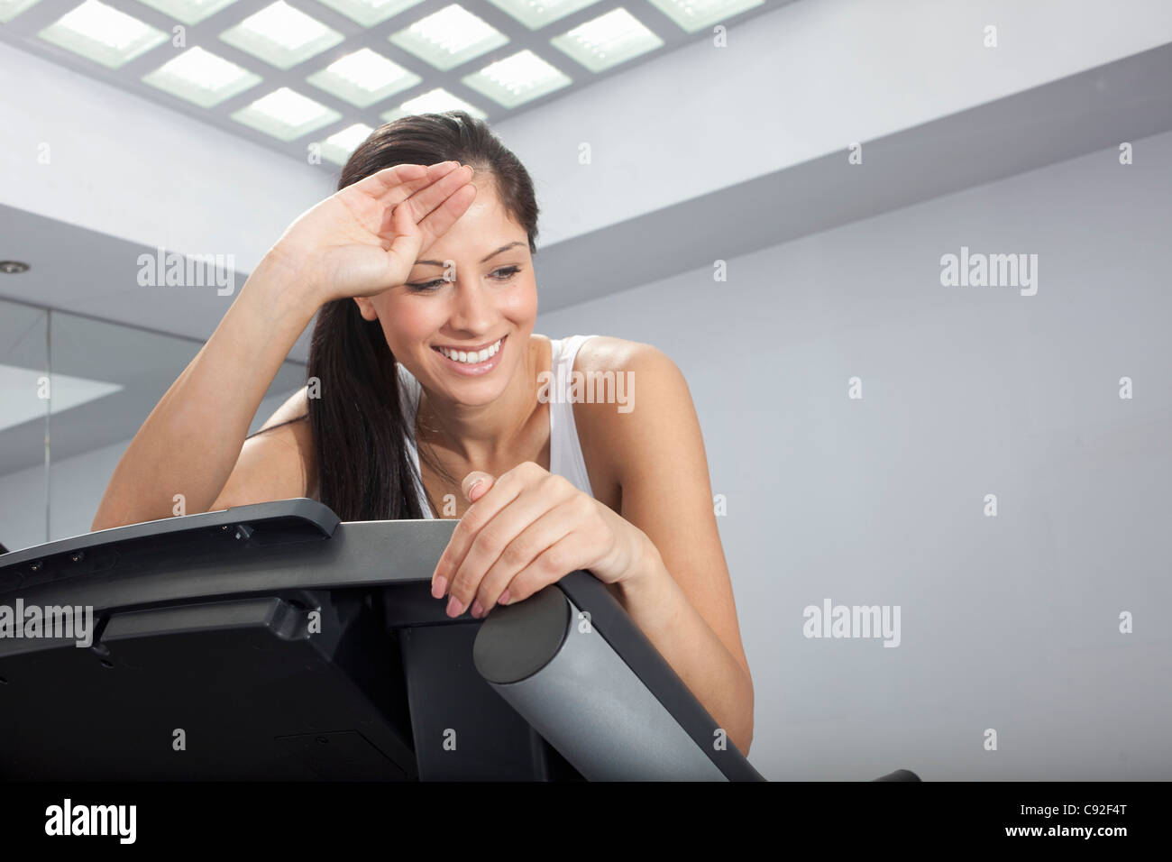 Smiling woman resting on treadmill Stock Photo - Alamy